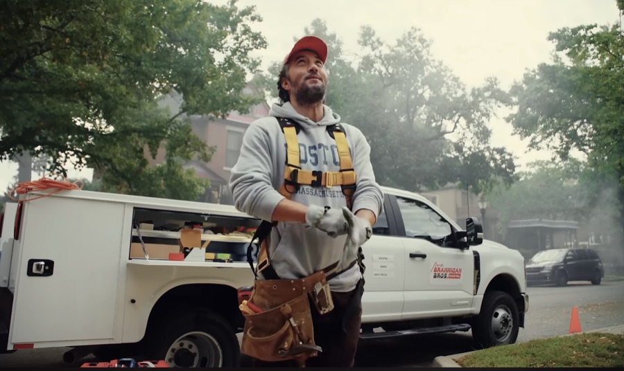 Max in work gear and harness in front of a Knapheide service truck on location