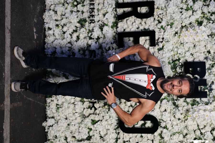 Max at a Beverly Hills event in front of a white floral wall