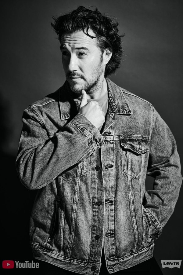 Max in a Levi’s denim jacket, hand to chin, black and white editorial portrait